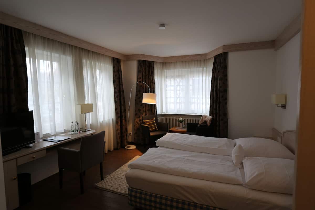 Een hotelkamer met een bed, bureau, stoel en televisie.