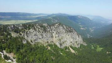 Eine gebirgige Landschaft mit dichten Wäldern und steilen Felswänden.