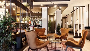 A modern lounge area with comfortable seating, a coffee table, and a bookshelf.