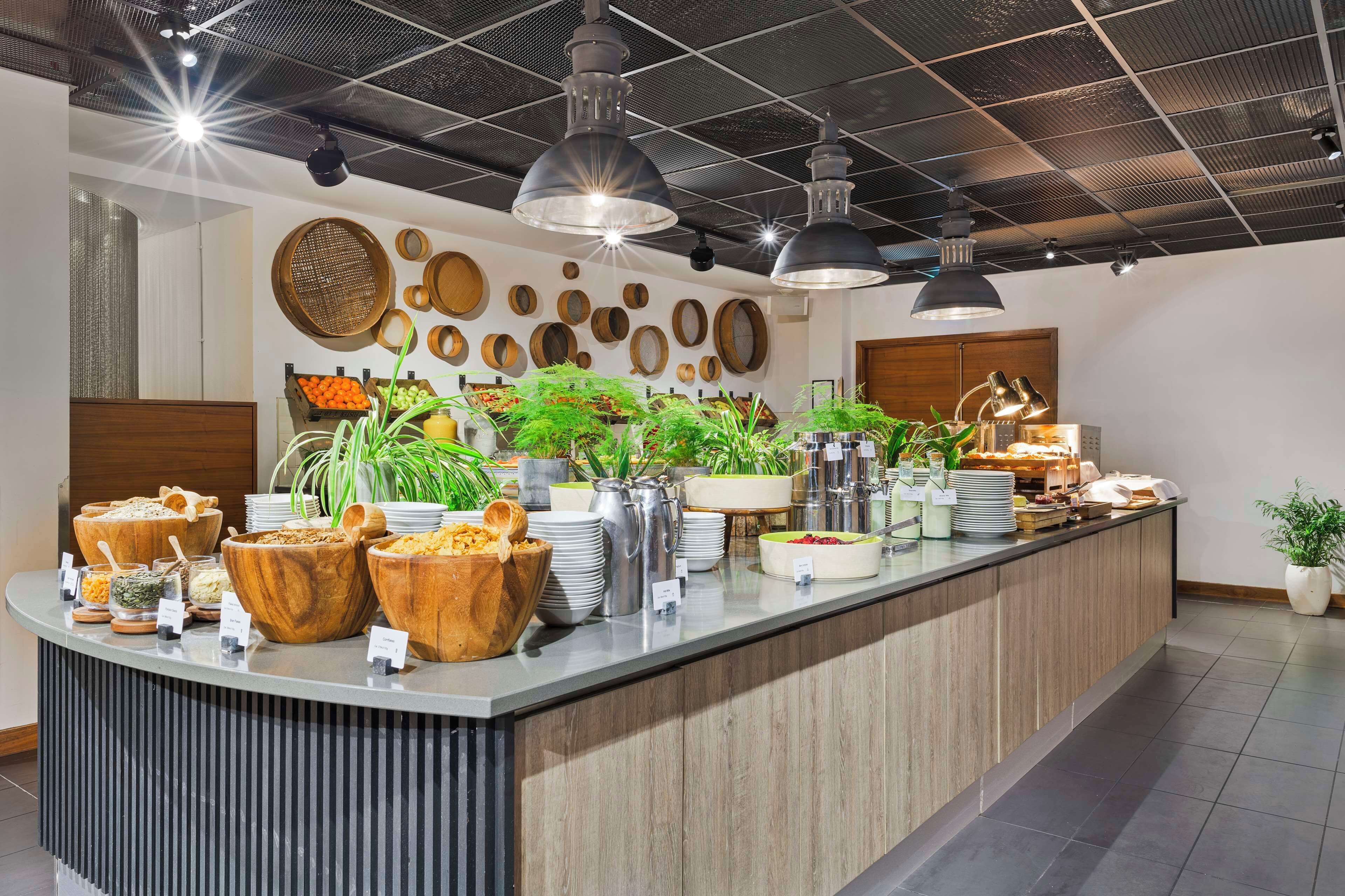 A buffet setup with various food items and a decorative wall with circular wooden objects.