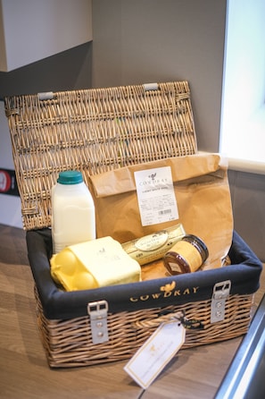 A wicker basket with a label, a milk carton, a brown paper bag, and a yellow item.