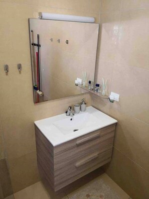 Regadera, secadora de cabello, toallas, papel de baño 