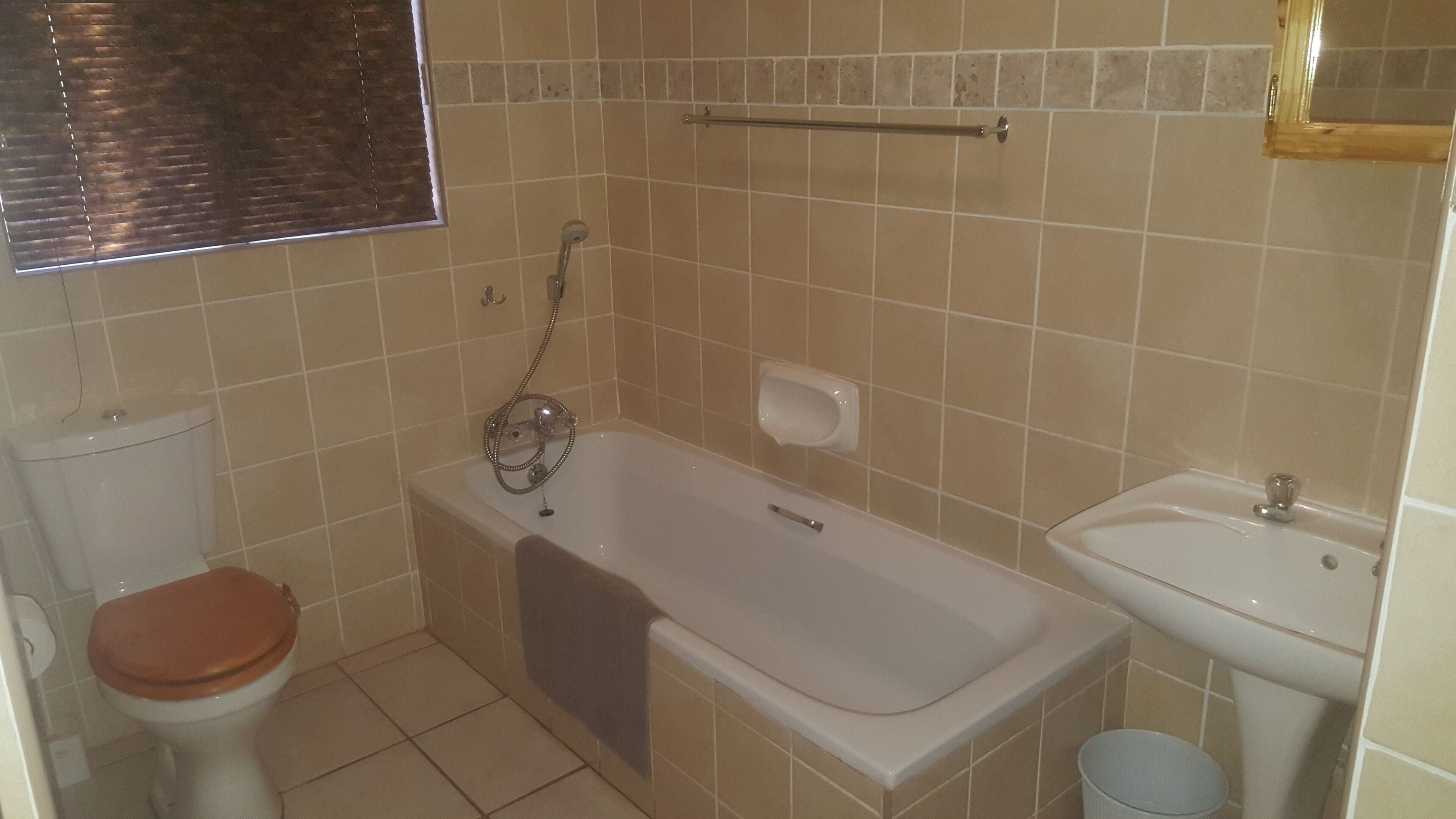 A bathroom with a bathtub, toilet, and sink.