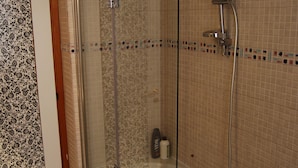 Une salle de bain moderne dotée d’une douche à parois de verre, d’une baignoire et de toilettes.