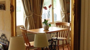 Een eethoek met een tafel, stoelen en een grote spiegel die de ruimte weerspiegelt.