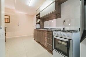 A modern kitchen with a gas stove, oven, and microwave.