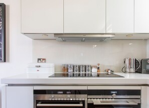Enjoy cooking in this well-equipped kitchen with a stainless steel range hood, appliances, and ample countertop space.