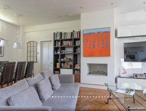 Relax in this stylish living room with a sofa, coffee table, bookshelf, and fireplace.