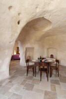 Zona pranzo con pavimento in pietra e tavolo apparecchiato per quattro persone.