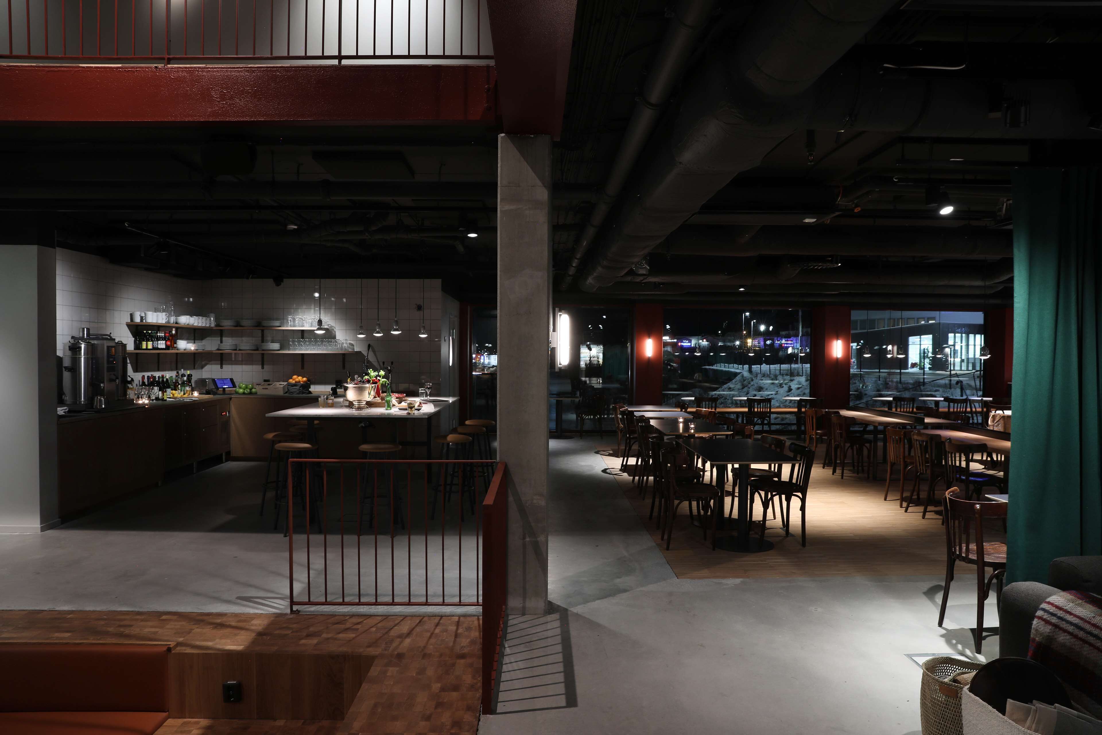 En modern restaurang med en bardel, bord och stolar.