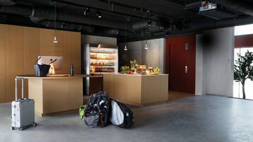 En modern hotellobby med en receptionsdisk, en minibar och en sittgrupp.
