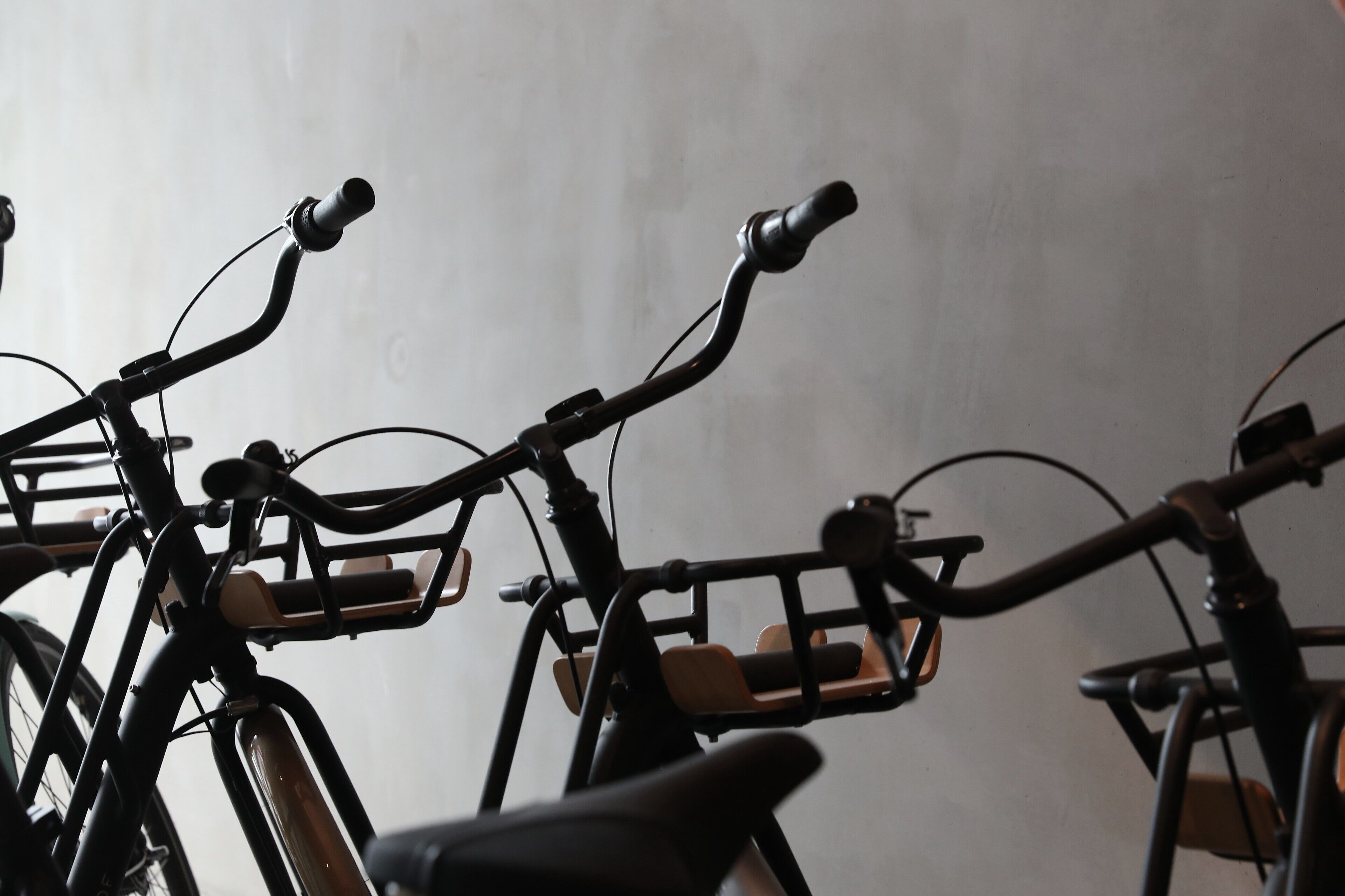 Varias bicicletas estáticas en una habitación con una pared lisa.