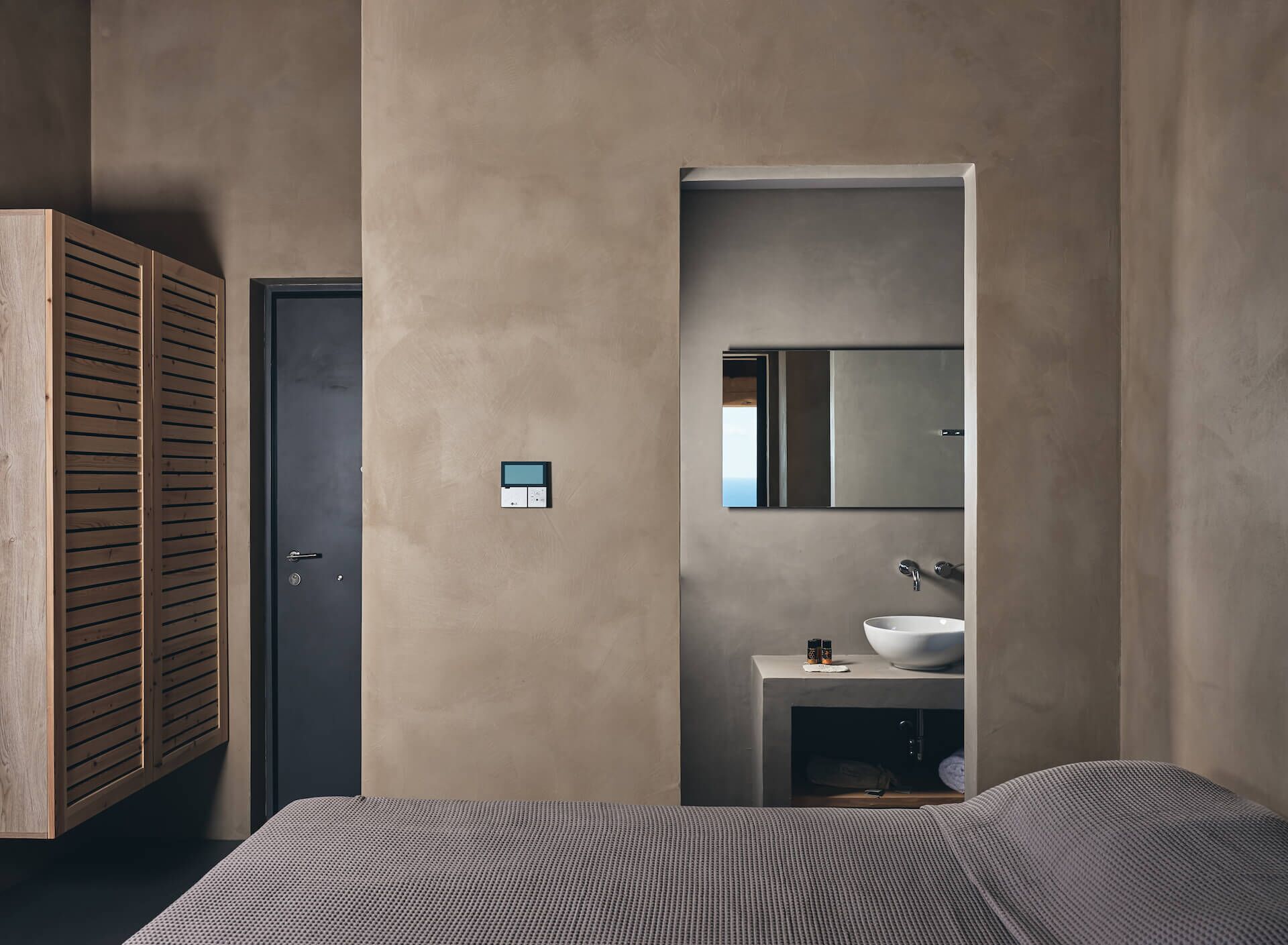 Ein modernes Badezimmer mit integriertem Waschbecken, einem Spiegel und einer Tür.