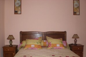 A bed with floral bedding and two nightstands with lamps.