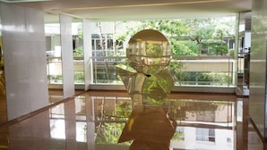A modern interior with a reflective floor, a large glass window, and a metallic sculpture. - Schloesing, 16e Tour Eiffel, Luxueux pied à terre (Paris)