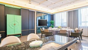 A modern conference room with a marble table, comfortable chairs, a large TV, and a green cabinet. - Rendezvous Hotel (CHANGZHI)