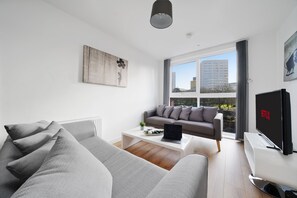 Departamento, 2 habitaciones | Área de sala de estar | Smart TV de 43 pulgadas con canales digitales, televisión y Netflix 