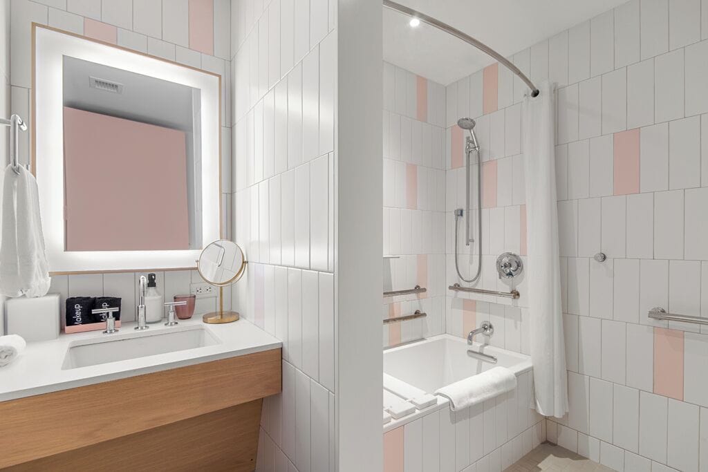 Ein modernes Badezimmer mit Waschtisch, Spiegel und Dusche.