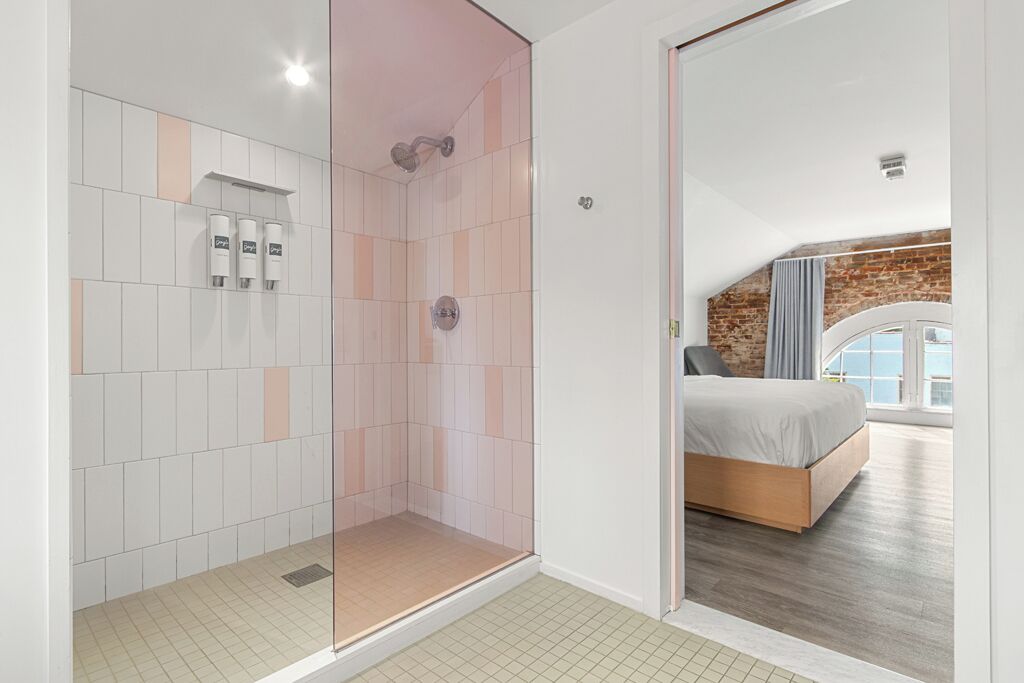 Un baño moderno con cabina de ducha de vidrio, un área separada para el inodoro y un cabezal de ducha visible.