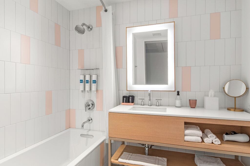 A modern bathroom with a bathtub, a sink with a mirror, and a shower.