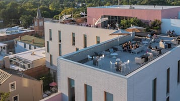 Terraza en la azotea con mobiliario exterior y vistas a la ciudad.