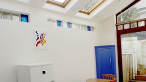 Una cocina compacta con tragaluces, un refrigerador blanco y un mueble azul.