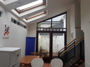 A compact room with a skylight, a dining area, and a staircase.