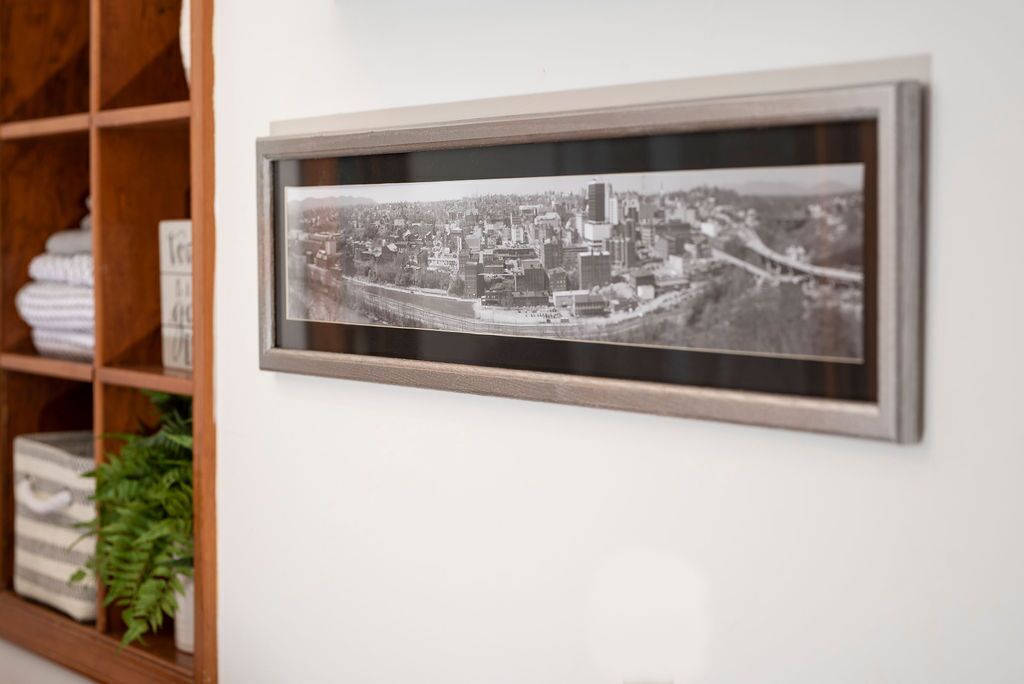 A framed black and white photograph of a cityscape on a wall.