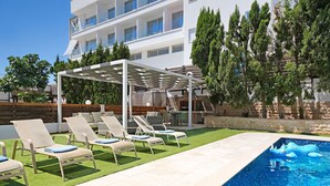 A poolside area with lounge chairs, a pergola, and a pool with a blue inflatable toy. - EMILY - 3Bed Villa within walking distance to FIG TREE BAY BEACH (Paralimni)