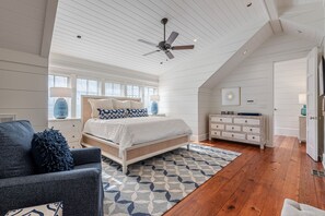 A bedroom with a bed, a ceiling fan, a dresser, and a nightstand. - Beautiful Remodeled Home | Quick Stroll to Town Center and Beach Club + Bikes (Santa Rosa Beach)