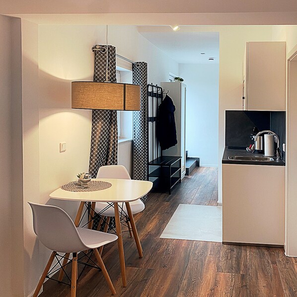Una cocina moderna con comedor, suelo de madera y un banco empotrado.
