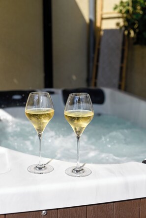 Two glasses of white wine on a white table in front of a hot tub. - Champagne Philippe Martin (Cumières)