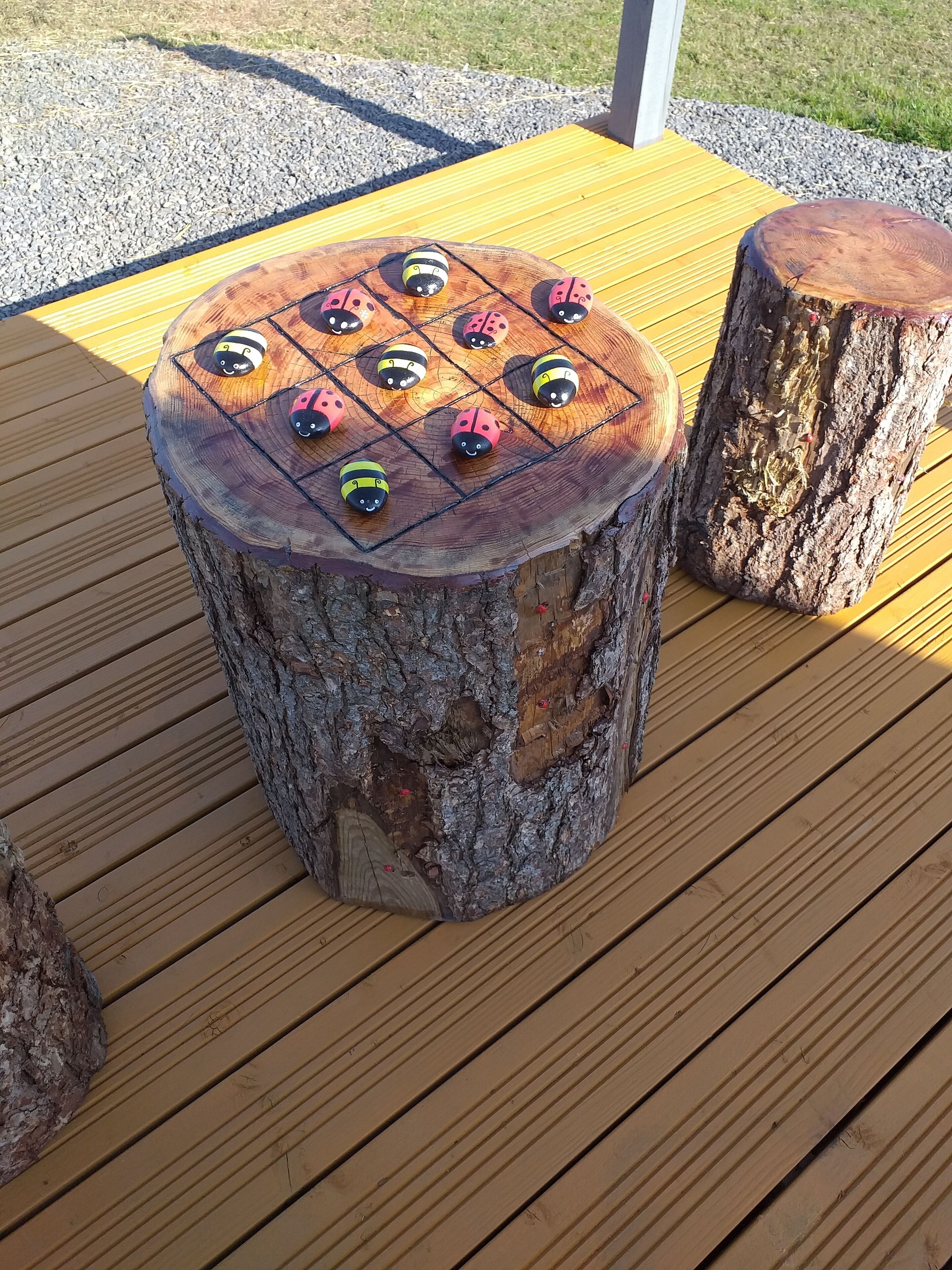 Una mesa de madera con un tablero redondo y con textura, que presenta un diseño de cuadrícula.