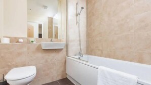 Une salle de bain comprenant des toilettes, un lavabo et une baignoire.