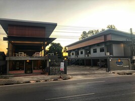 A building with a modern architectural style, featuring a flat roof and a mix of glass and solid walls. There is a sign indicating the name of the establishment and a visible entrance.