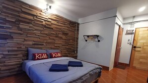 A bedroom with a wooden headboard, a bed with blue bedding, and two pillows with 'Kiss' text. - Pakarang Resort (La-ngu)