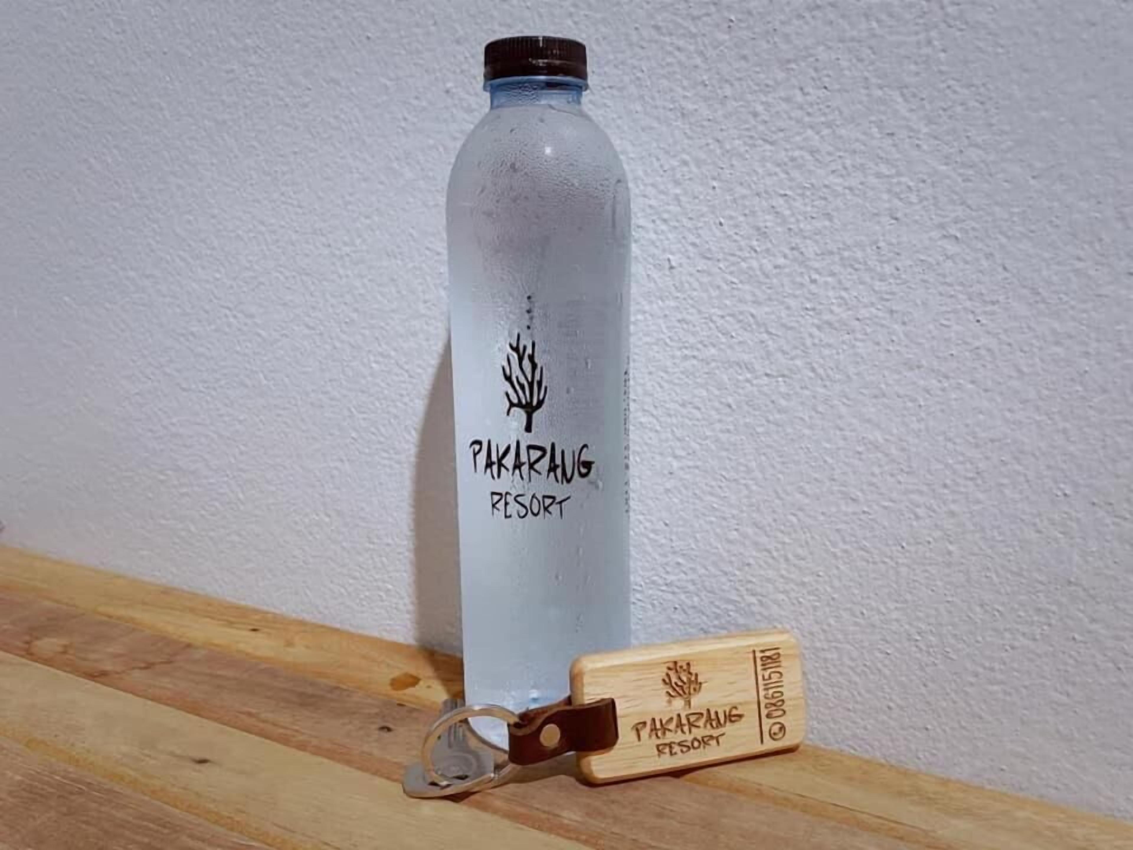 Una botella de agua y un llavero de madera con el texto 