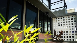 A modern building with large windows, a brick facade, and a white lattice structure. - Pakarang Resort (La-ngu)