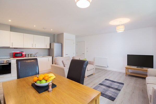 A modern apartment with a kitchen, dining area, and living room.
