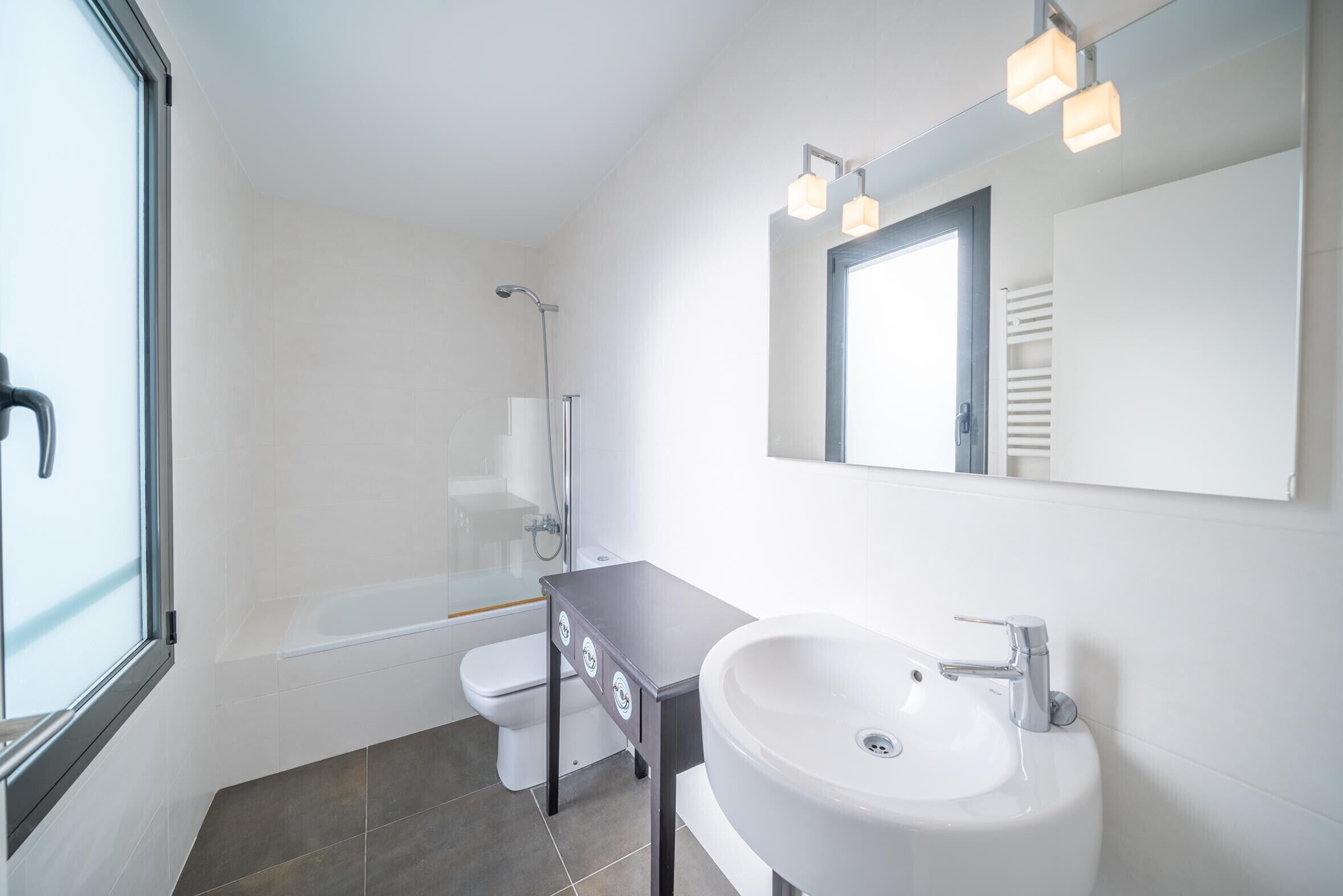 A modern bathroom with a bathtub, toilet, and sink.