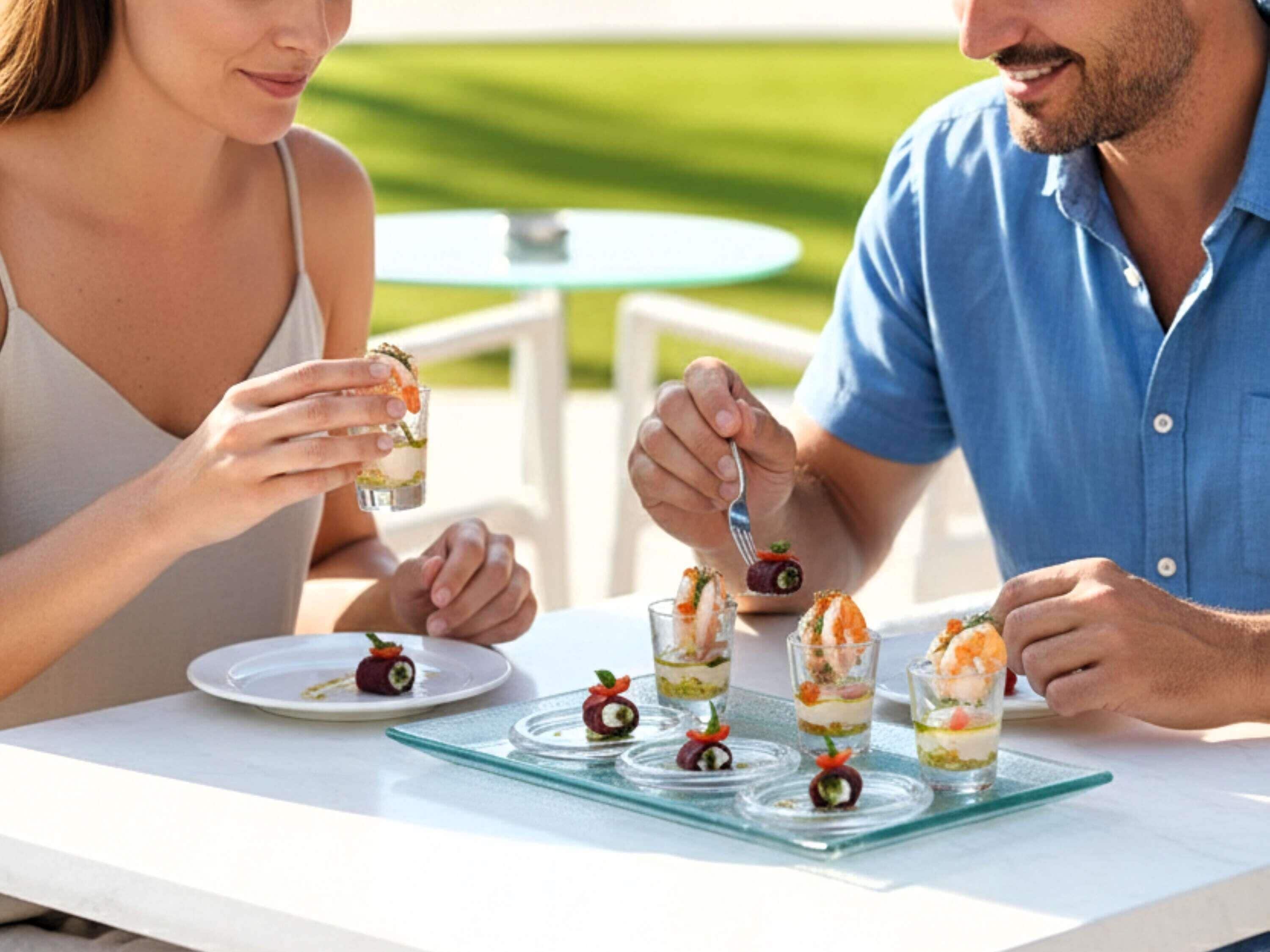 A couple dining outdoors with a table set for a meal.
