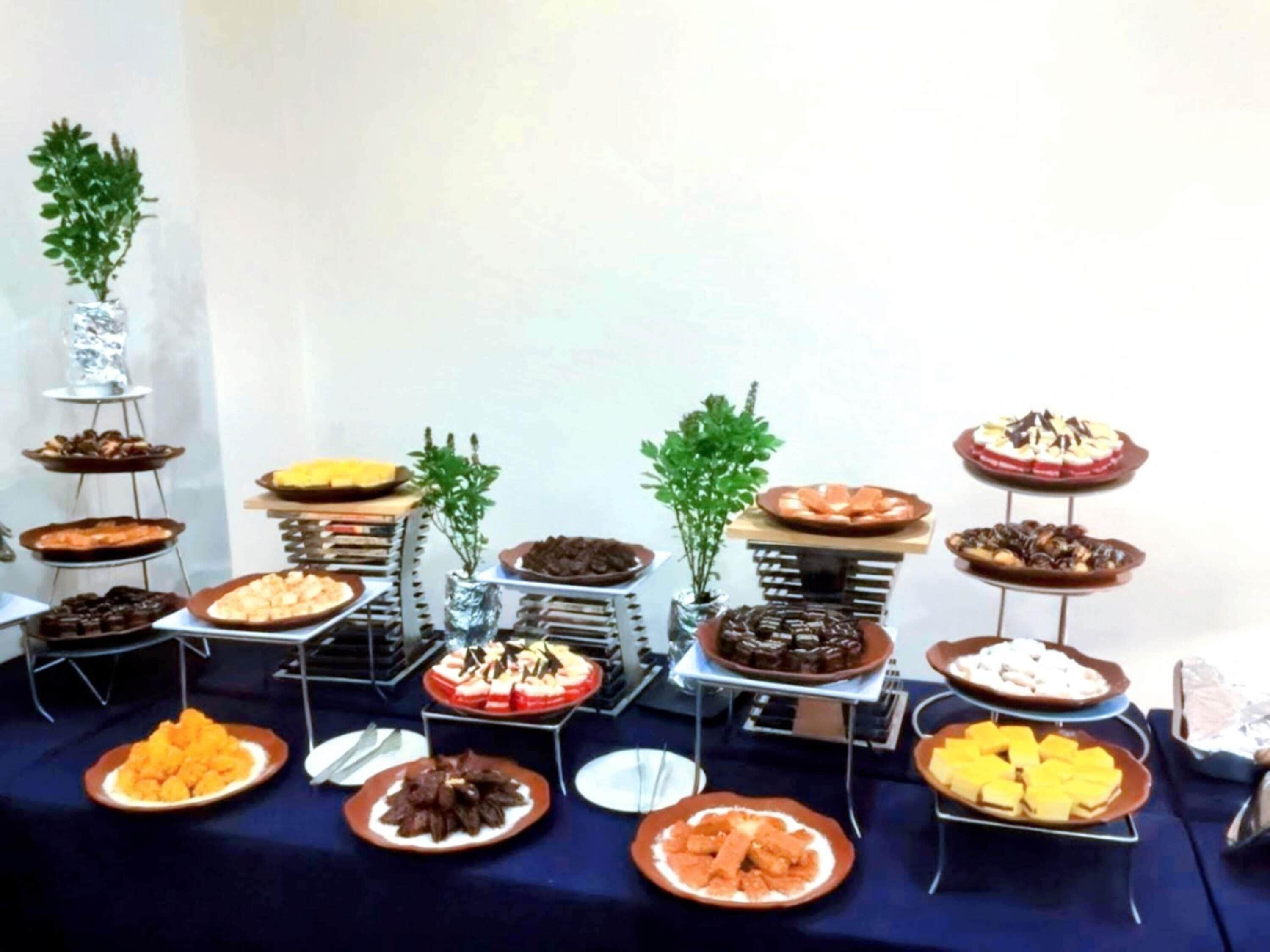 A buffet table with various dishes and desserts.