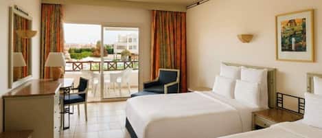 A hotel room with two beds, a desk, a chair, and a balcony with a view.