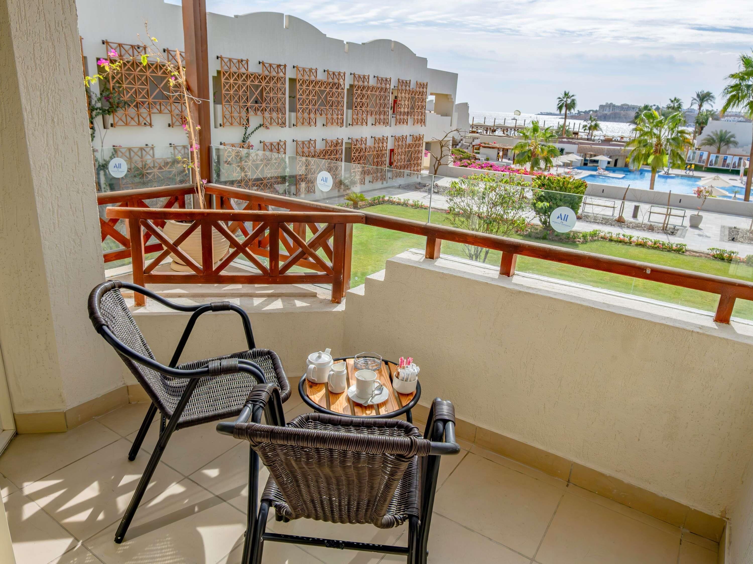 Deluxe-rum - 2 queensize-sängar - utsikt mot poolen - vid stranden | Minibar, värdeförvaringsskåp på rummet och strykjärn/strykbräda