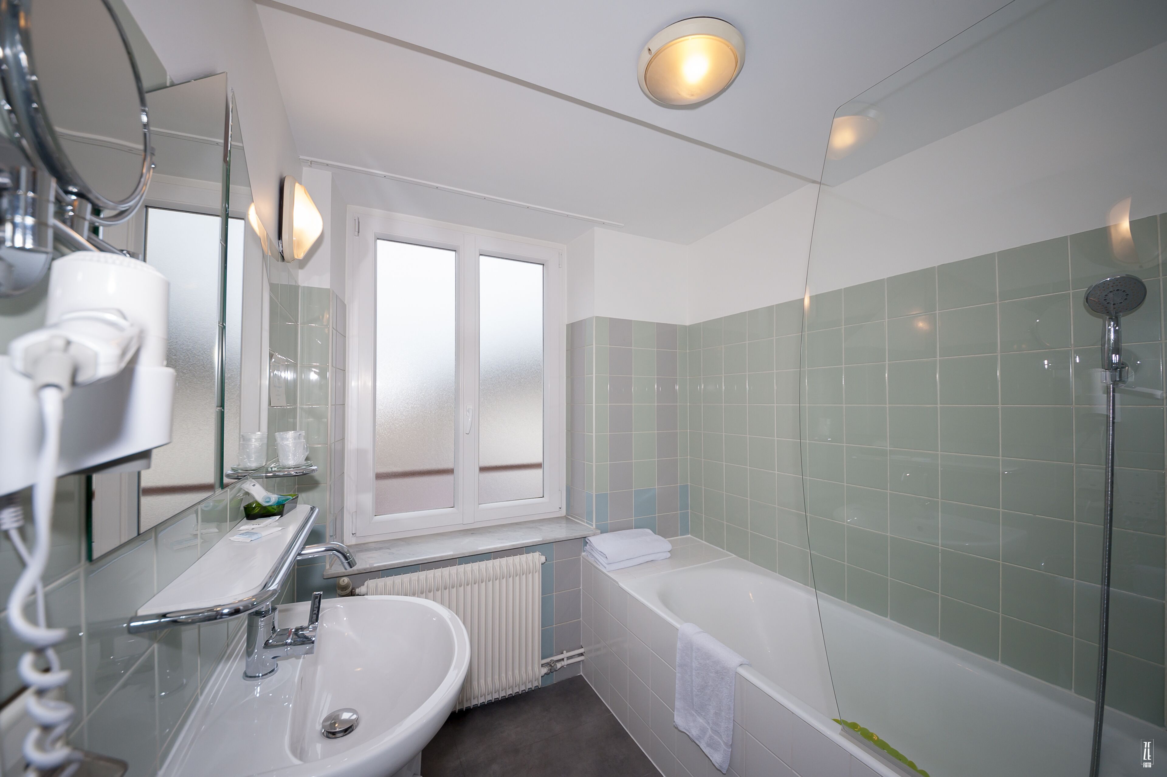 Ein modernes Badezimmer mit Waschbecken, Spiegel und Duschkabine aus Glas.