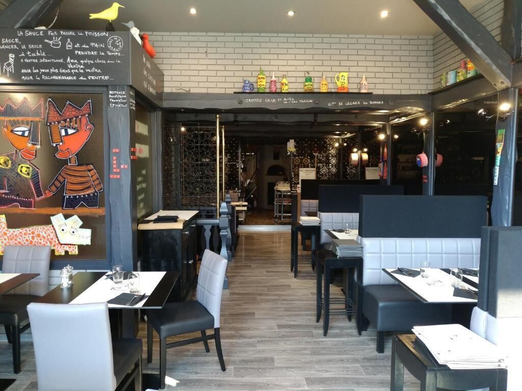 Ein Restaurantinneres mit Sitzecken und Tischen, einer Tafeln mit Speisekarte und einer cartoonartigen Dekoration.