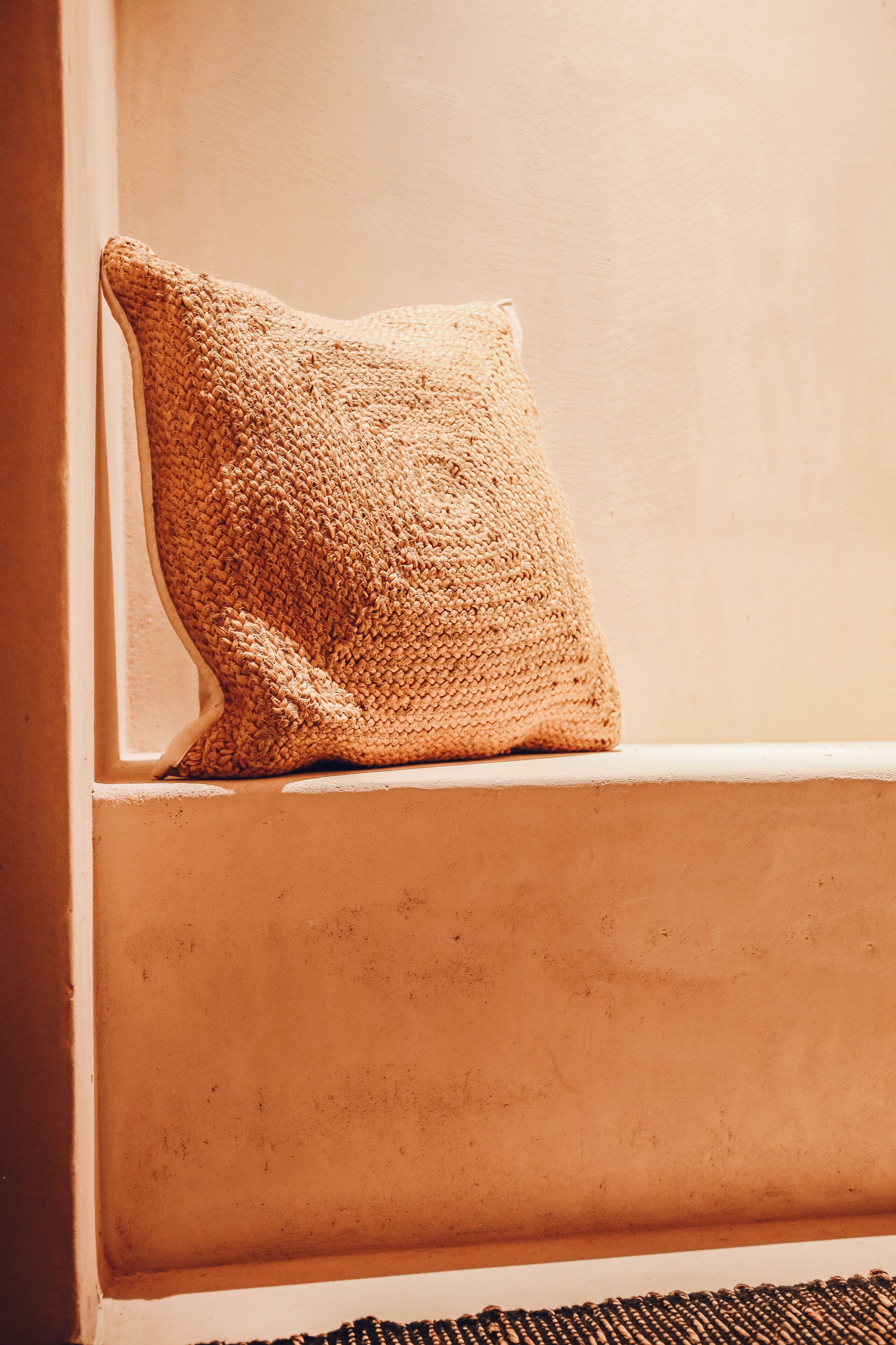 A textured beige pillow on a white window sill.
