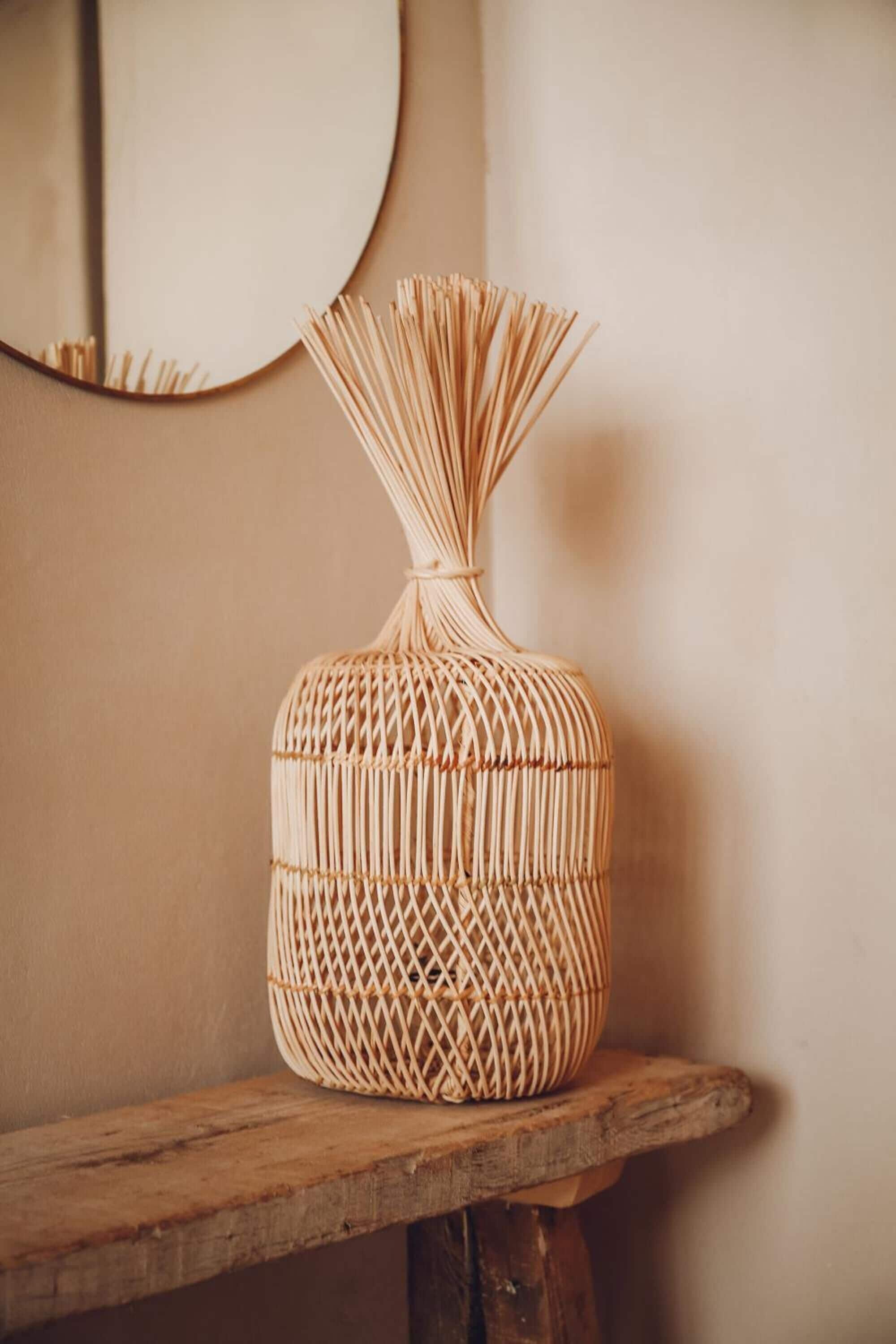 A woven basket on a wooden shelf against a plain wall.
