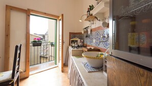 A kitchen with a tiled backsplash, a wooden cabinet, a sink, and a window with a view of the outside.