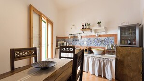 A kitchen with wooden furniture, a tiled backsplash, and a refrigerator.